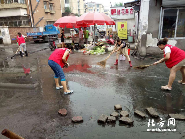 赵苑社区志愿者清扫雨后积水 创造良好出行条